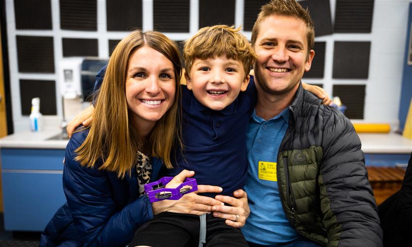 A student smiles with his parents